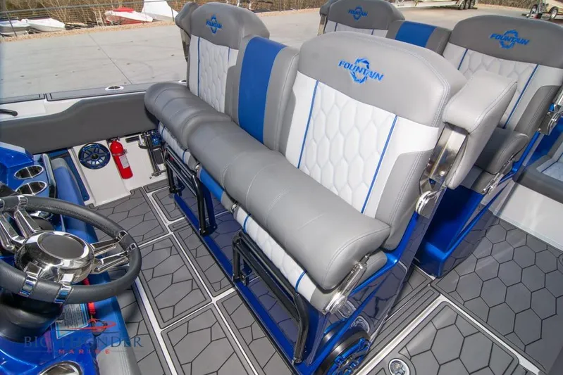  Yacht Photos Pics 2022 Fountain 38 SC boat interior with blue and gray seating and steering wheel.