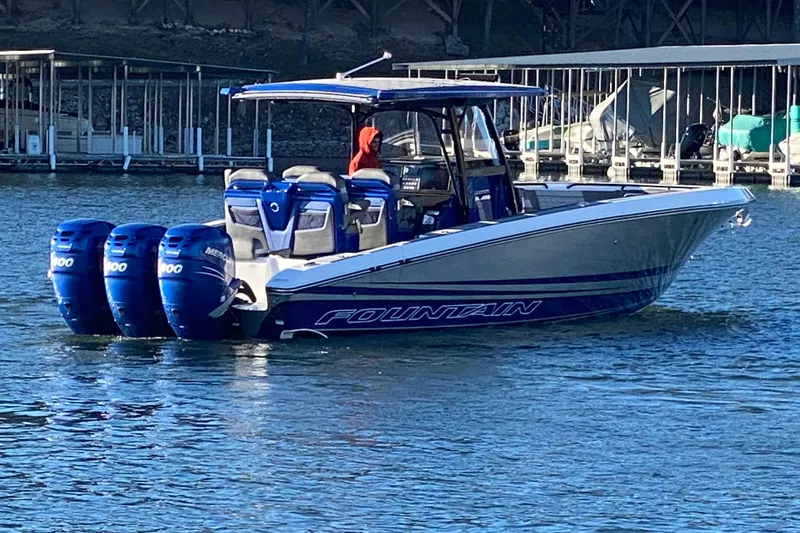  Yacht Photos Pics 2022 Fountain 38 SC boat with triple Mercury engines on a calm lake.