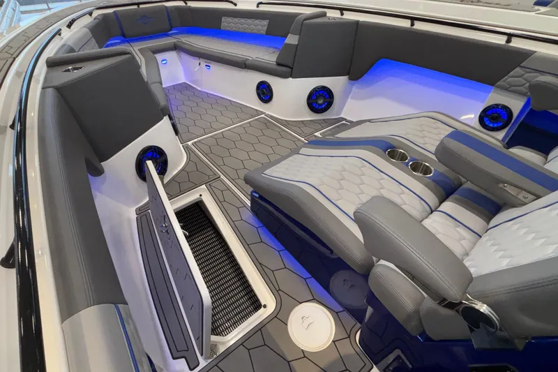  Yacht Photos Pics 2022 Fountain 38 SC boat interior with gray seating, blue lighting, and hexagonal flooring.