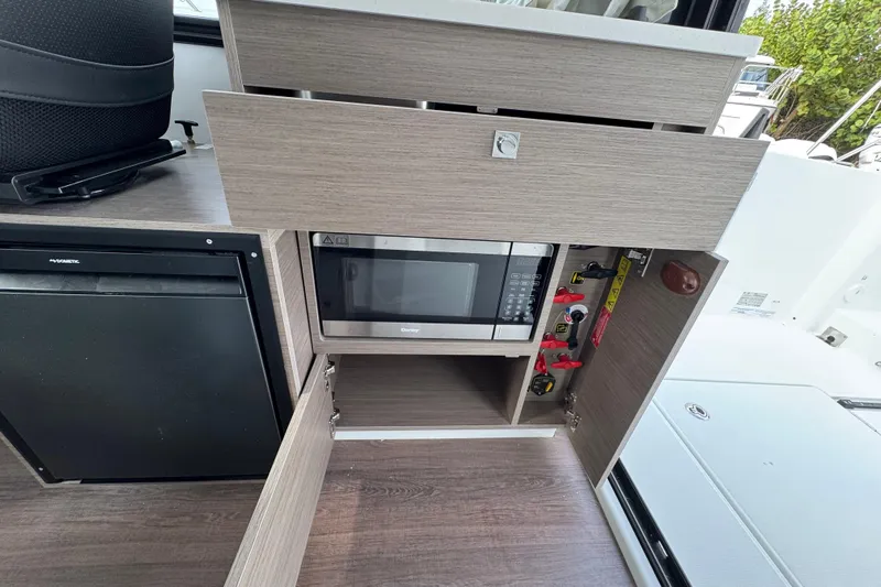  Yacht Photos Pics 2026 Jeanneau NC 895 Sport Series 2 interior with microwave and storage cabinets.