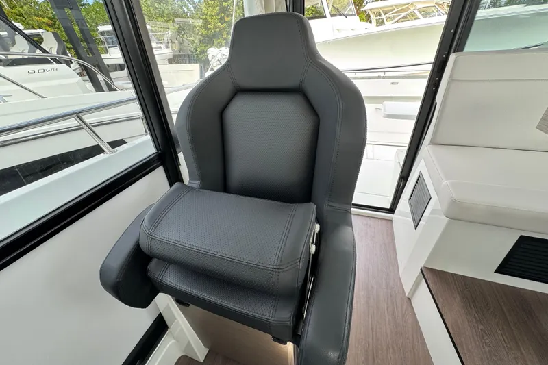  Yacht Photos Pics 2026 Jeanneau NC 895 Sport Series 2 interior with sleek black captain's chair.