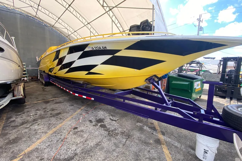  Yacht Photos Pics Yellow 1999 Fountain 47 Lightning boat on trailer under canopy.