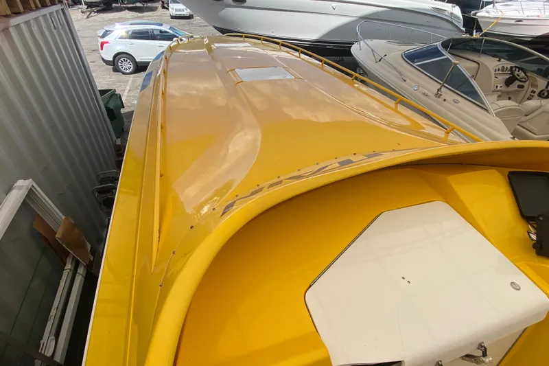  Yacht Photos Pics Yellow 1999 Fountain 47 Lightning boat in storage, surrounded by other vessels.
