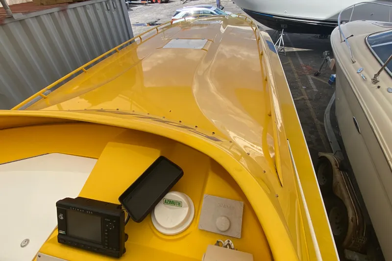  Yacht Photos Pics Yellow 1999 Fountain 47 Lightning boat with navigation equipment, docked among other boats.