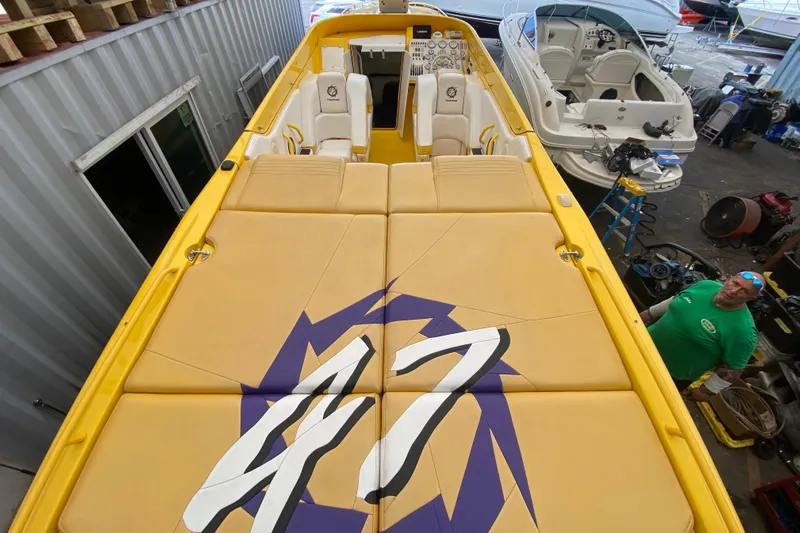  Yacht Photos Pics Yellow 1999 Fountain 47 Lightning boat with custom seating in a workshop setting.
