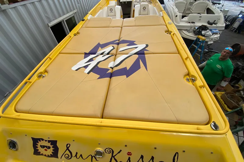 Yacht Photos Pics Yellow 1999 Fountain 47 Lightning boat with custom "Sun Kissed" design in a workshop.