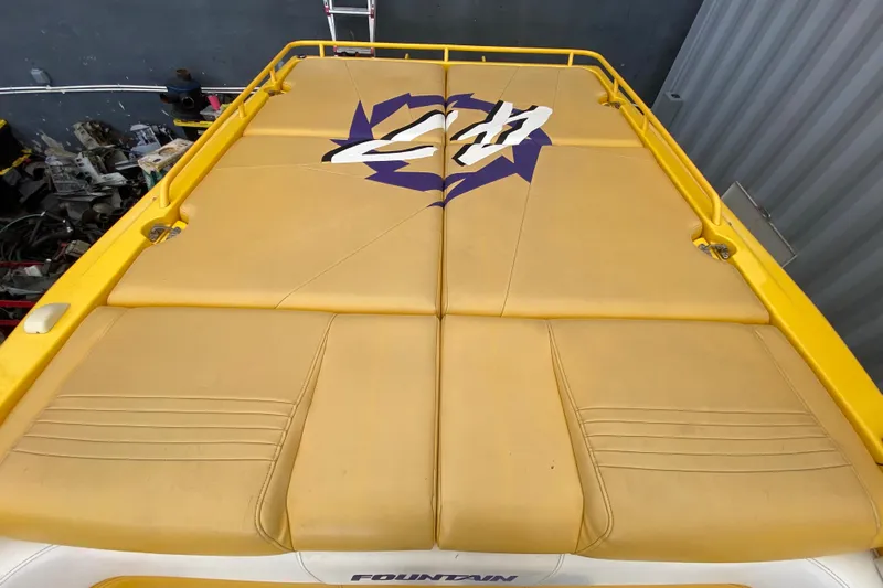  Yacht Photos Pics 1999 Fountain 47 Lightning boat with yellow cushioned deck and logo design.