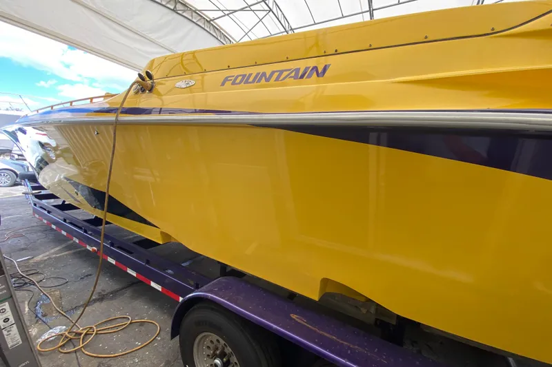  Yacht Photos Pics Yellow 1999 Fountain 47 Lightning boat on trailer under canopy.