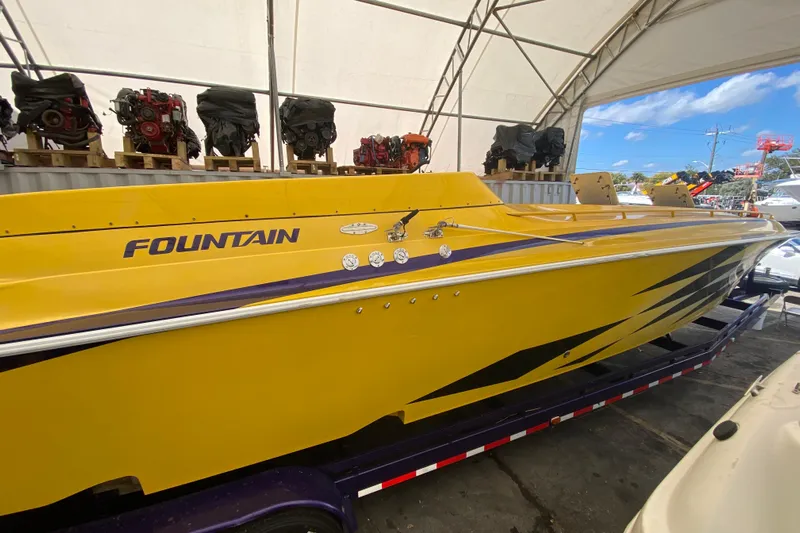 Yacht Photos Pics Yellow 1999 Fountain 47 Lightning speedboat in storage, surrounded by engines.