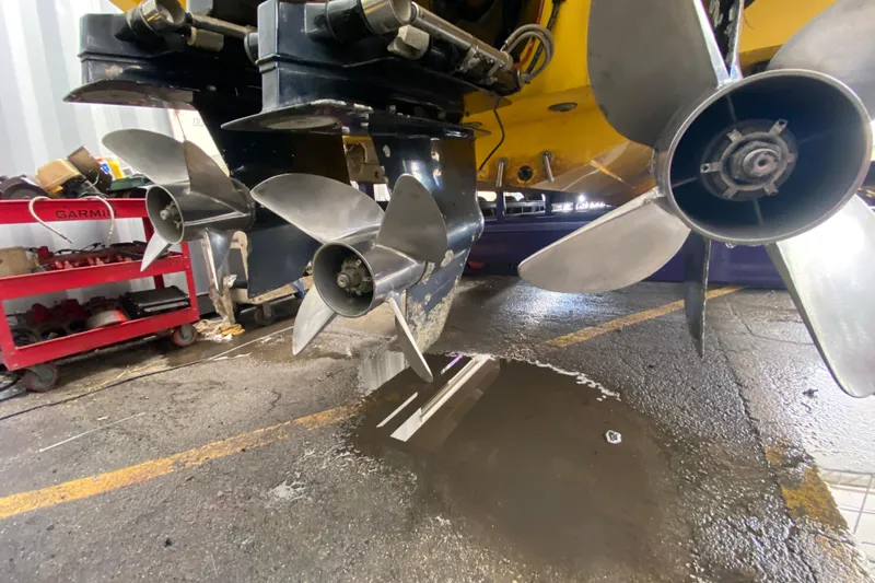  Yacht Photos Pics Close-up of 1999 Fountain 47 Lightning boat propellers in a workshop setting.