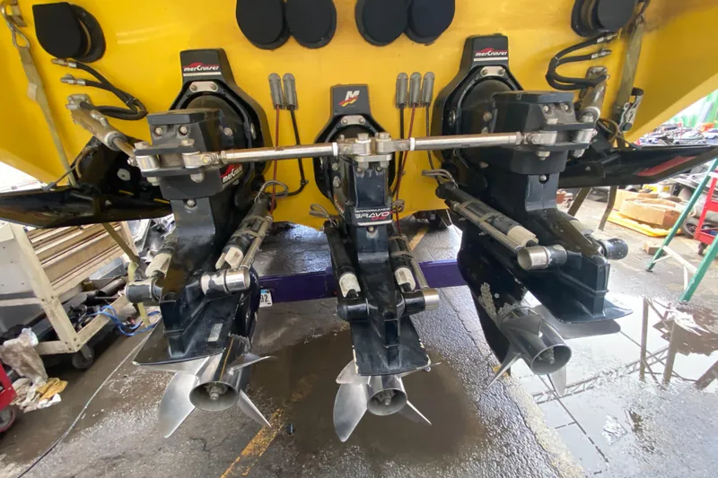  Yacht Photos Pics 1999 Fountain 47 Lightning boat with triple MerCruiser Bravo engines in a workshop setting.