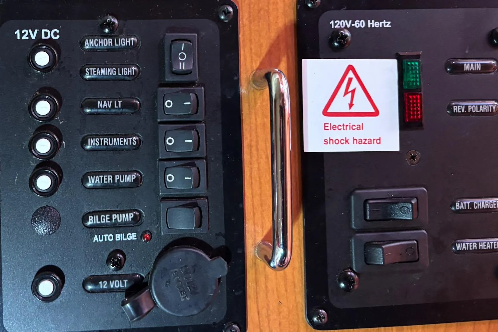Control panel of a 2008 Hunter 27 boat with electrical switches and hazard warning.