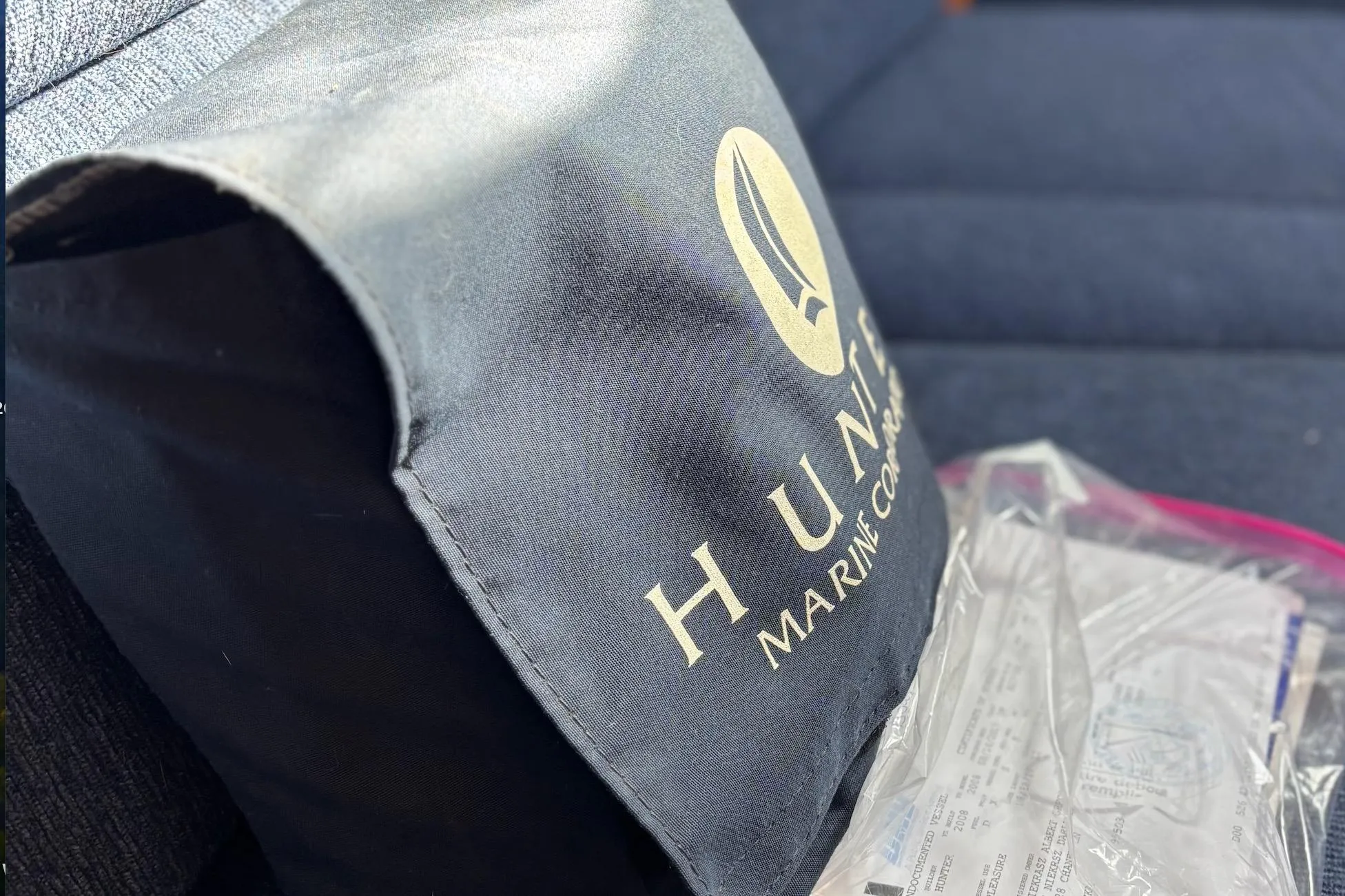 Hunter Marine Corporation bag on a blue seat, with documents in a plastic bag.
