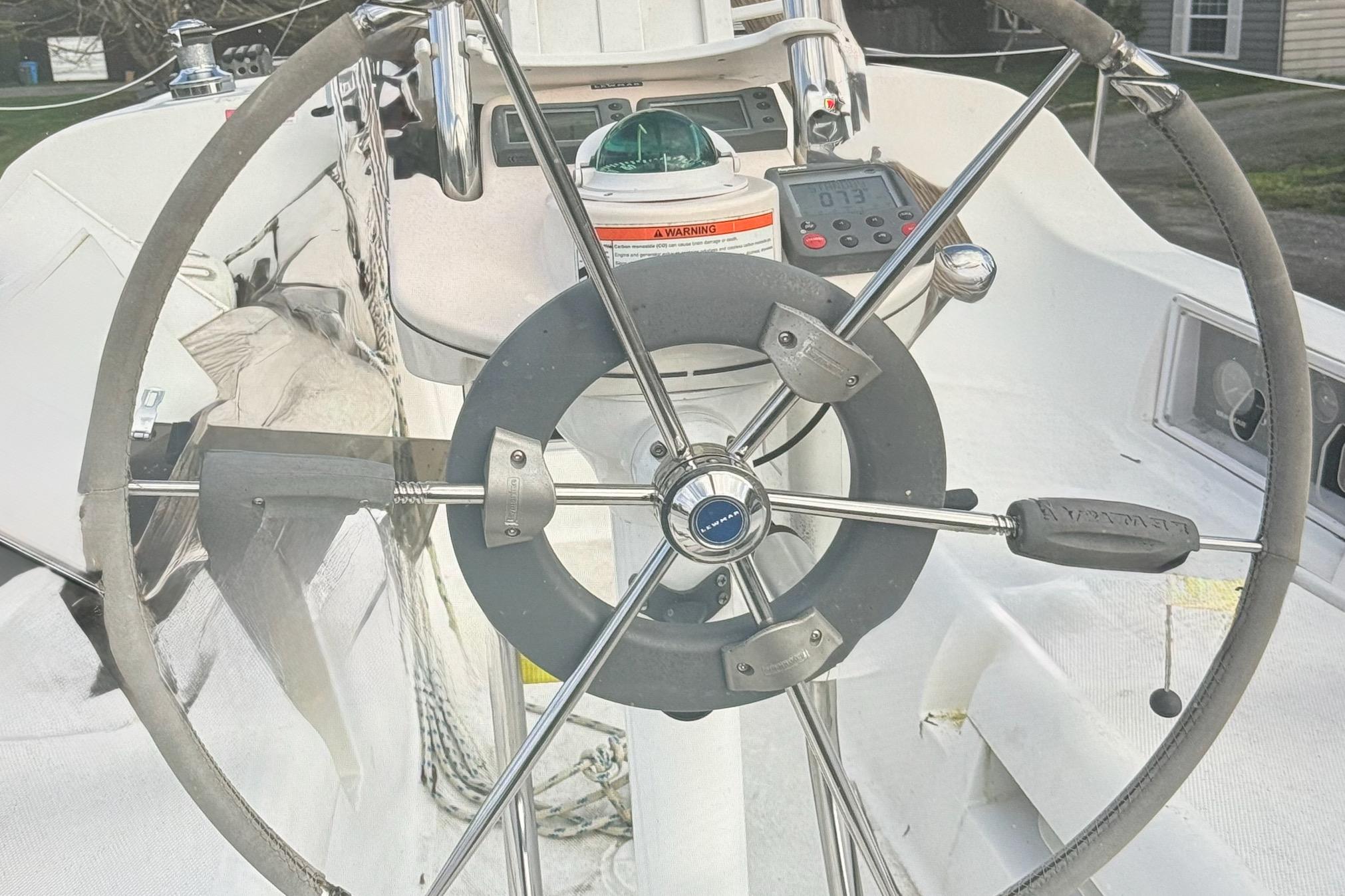 Steering wheel of a 2008 Hunter 27 sailboat, featuring navigation instruments.