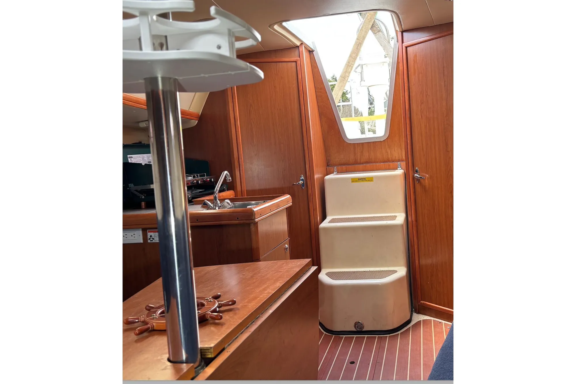 Interior of 2008 Hunter 27 sailboat with wooden cabinetry and steps.