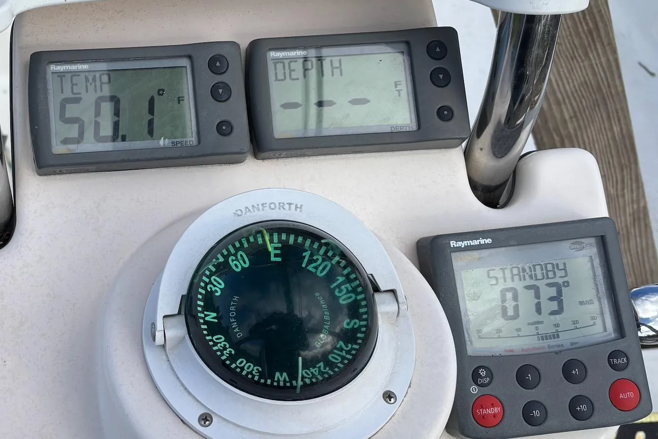 Control panel of a 2008 Hunter 27 sailboat with compass and Raymarine displays.