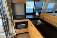 Interior of 2017 Azimut Magellano 53 yacht kitchen with wood finish and ocean view.
