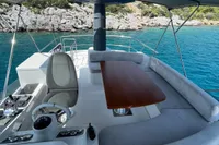 Flybridge of 2017 Azimut Magellano 53 yacht with seating and table, overlooking turquoise waters.