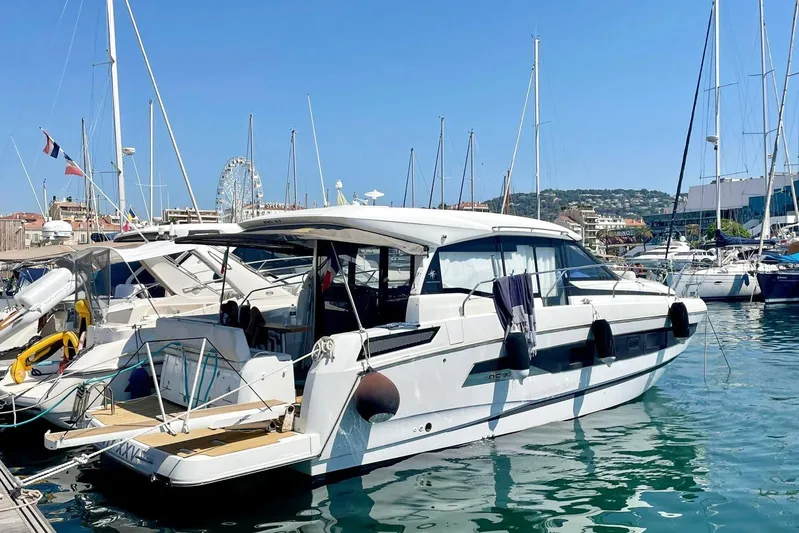  Yacht Photos Pics 2021 Jeanneau NC 37 yacht docked in a sunny marina, surrounded by other boats.