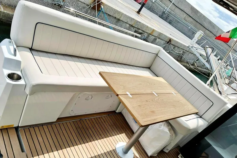  Yacht Photos Pics 2021 Jeanneau NC 37 boat with white seating and wooden table on deck.