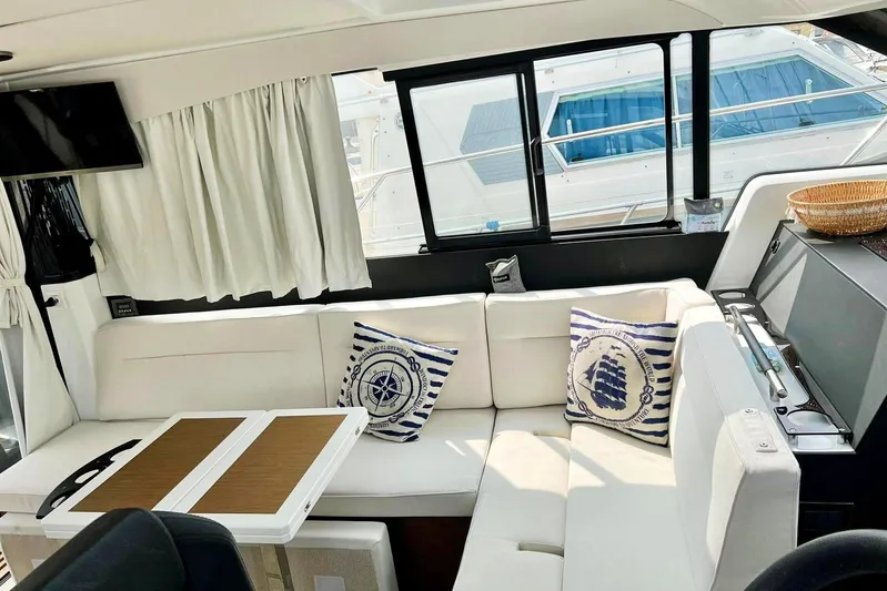  Yacht Photos Pics Interior of 2021 Jeanneau NC 37 yacht with cozy seating and nautical-themed decor.