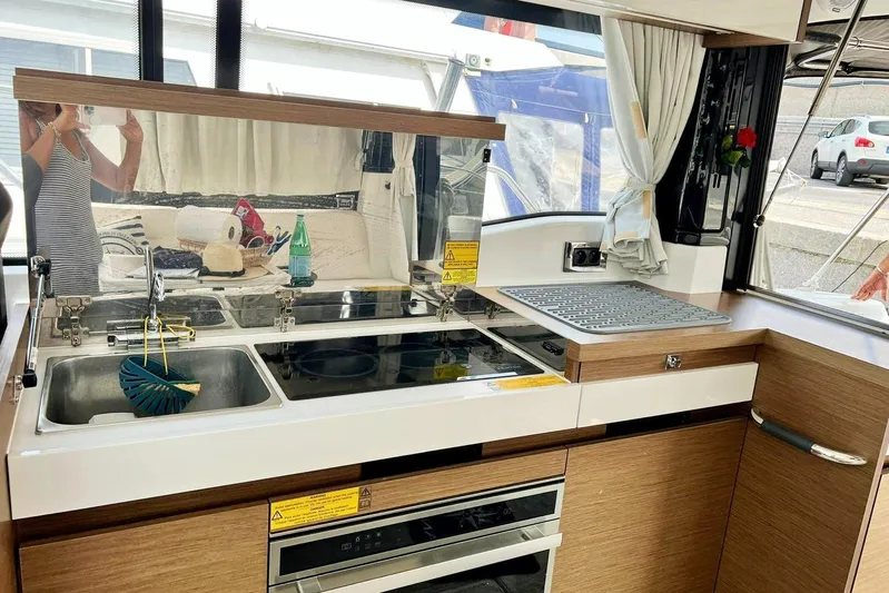  Yacht Photos Pics Modern kitchen area in a 2021 Jeanneau NC 37 boat, featuring a sink and stove.