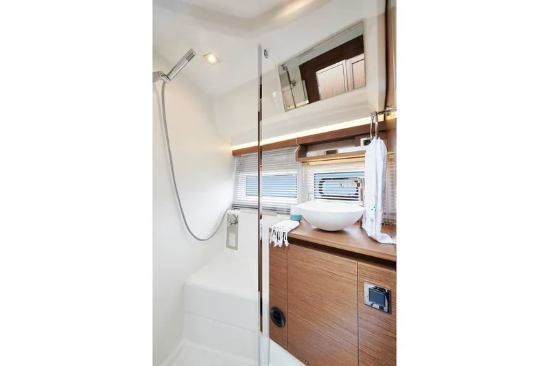  Yacht Photos Pics Modern bathroom interior of 2021 Jeanneau NC 37 yacht with sleek fixtures and wooden cabinetry.