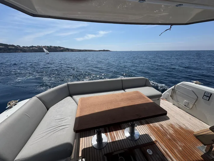  Yacht Photos Pics Luxurious 2023 Prestige 460 yacht deck with seating, table, and ocean view.