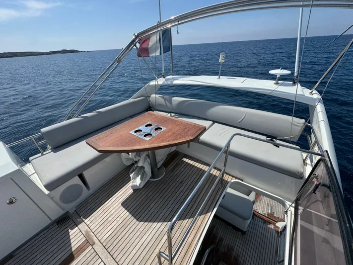  Yacht Photos Pics 2023 Prestige 460 yacht deck with seating and table, overlooking the ocean.