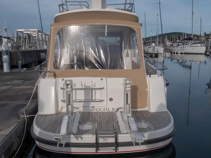 Seahawk Yacht Photos Pics Nimbus 405 Flybridge 2017 yacht docked at marina, rear view with tan canopy.
