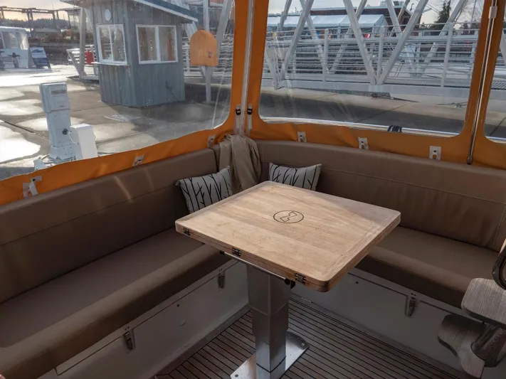 Seahawk Yacht Photos Pics Cozy seating area on 2017 Nimbus 405 Flybridge with wooden table and cushions.