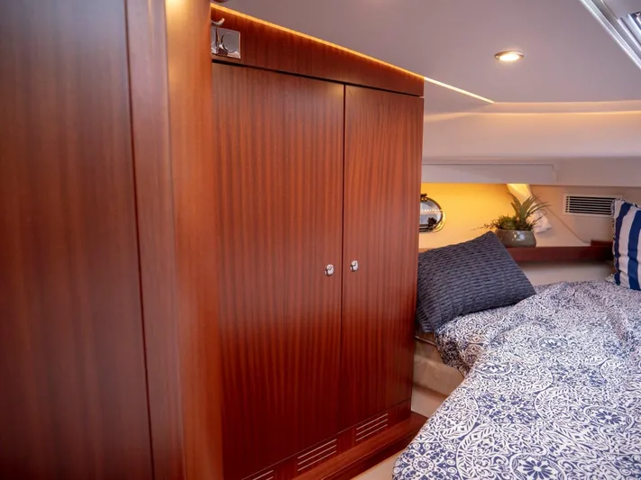 Seahawk Yacht Photos Pics Luxurious cabin interior of 2017 Nimbus 405 Flybridge with wooden wardrobe and patterned bedding.