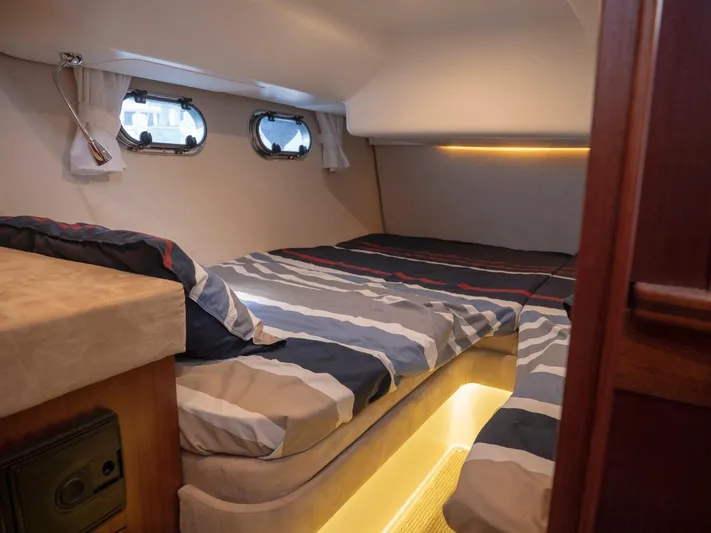 Seahawk Yacht Photos Pics Cozy cabin interior of 2017 Nimbus 405 Flybridge with striped bedding and ambient lighting.