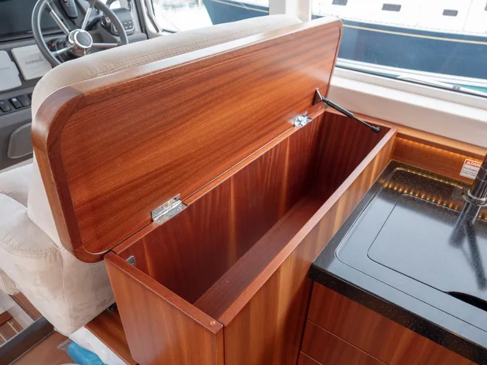 Seahawk Yacht Photos Pics Open wooden storage compartment on 2017 Nimbus 405 Flybridge yacht interior.