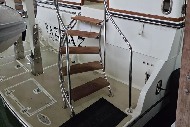 Pazzaz Yacht Photos Pics Staircase on 1985 Chris-Craft 500 Constellation Motor Yacht deck, featuring wooden steps and metal railings.