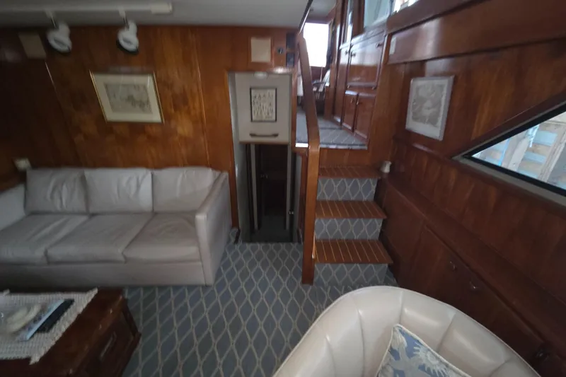 Pazzaz Yacht Photos Pics Interior of 1985 Chris-Craft 500 Constellation Motor Yacht with wood paneling and seating area.