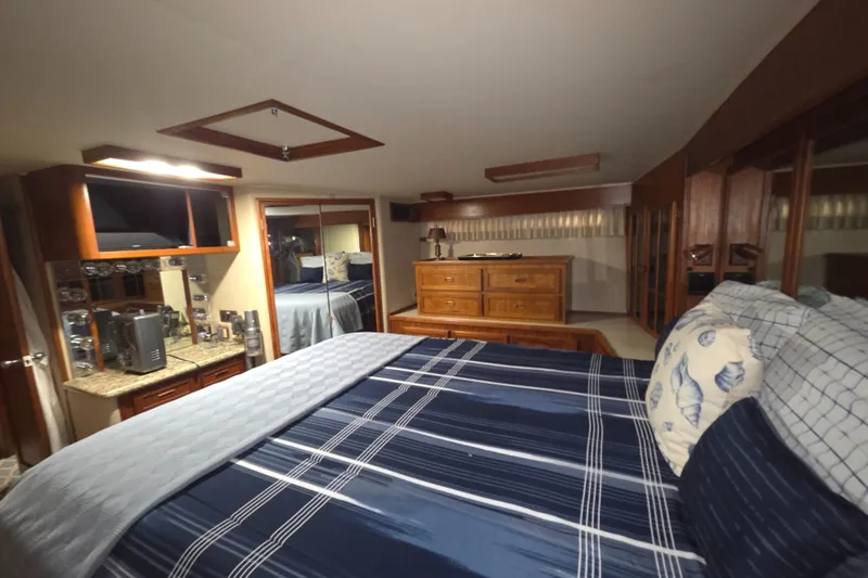 Pazzaz Yacht Photos Pics Luxurious bedroom interior of 1985 Chris-Craft 500 Constellation Motor Yacht with elegant wood furnishings.