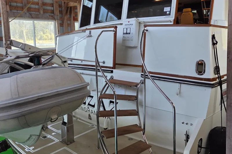 Pazzaz Yacht Photos Pics 1985 Chris-Craft 500 Constellation Motor Yacht with wooden steps and inflatable boat in a boathouse.