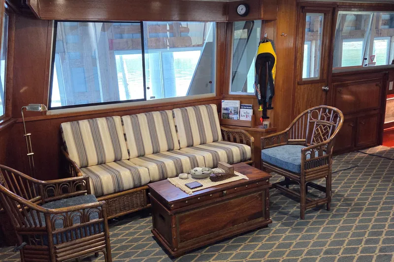 Pazzaz Yacht Photos Pics Interior of 1985 Chris-Craft 500 Constellation Motor Yacht with striped sofa and wooden furniture.