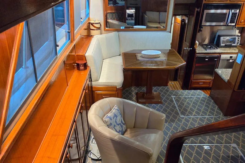 Pazzaz Yacht Photos Pics Luxurious interior of 1985 Chris-Craft 500 Constellation Motor Yacht with dining area and kitchen.