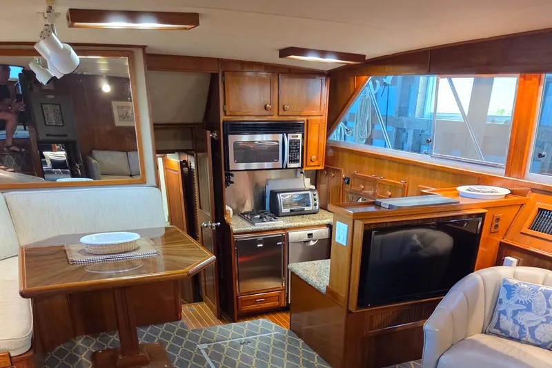Pazzaz Yacht Photos Pics Luxurious interior of 1985 Chris-Craft 500 Constellation Motor Yacht with kitchen and dining area.