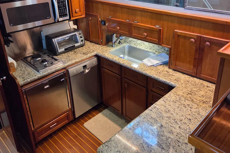 Pazzaz Yacht Photos Pics Luxurious kitchen in 1985 Chris-Craft 500 Constellation Motor Yacht with granite countertops and modern appliances.