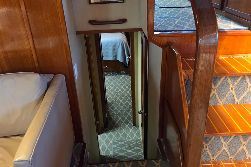 Pazzaz Yacht Photos Pics Interior of 1985 Chris-Craft 500 Constellation Motor Yacht with wooden stairs and carpeted hallway.