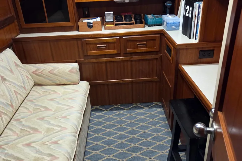 Pazzaz Yacht Photos Pics Interior of 1985 Chris-Craft 500 Constellation Motor Yacht with wood cabinetry and patterned sofa.