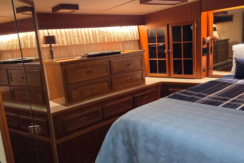Pazzaz Yacht Photos Pics Luxurious 1985 Chris-Craft 500 Constellation Motor Yacht bedroom with wood cabinetry and cozy bedding.