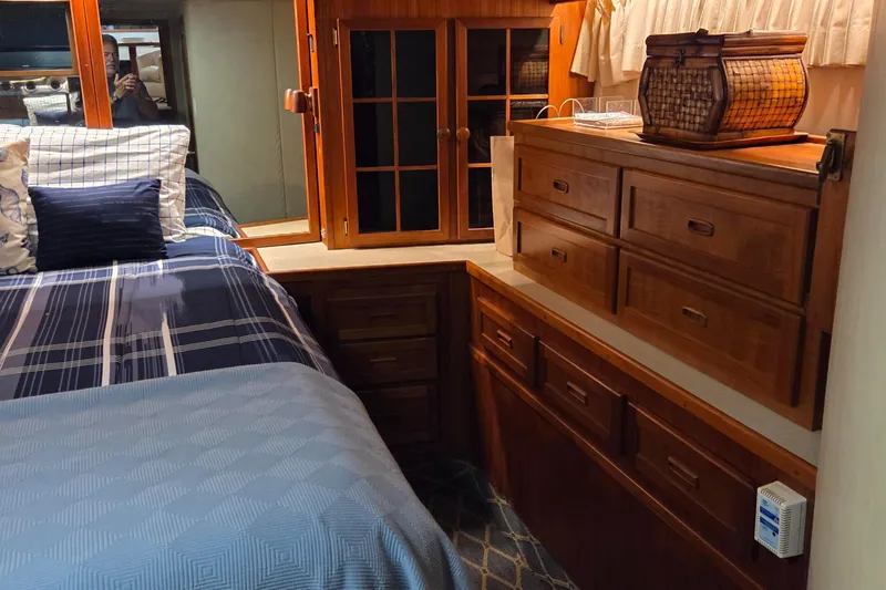 Pazzaz Yacht Photos Pics Luxurious 1985 Chris-Craft 500 Constellation Motor Yacht bedroom with wooden cabinetry and cozy bedding.