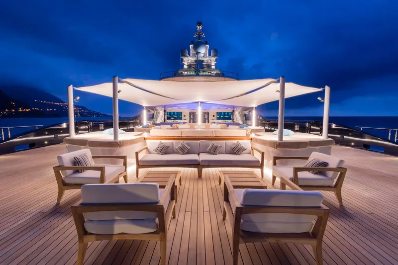Luna Yacht Photos Pics Luxurious yacht deck with elegant seating, ambient lighting, and ocean view at dusk.
