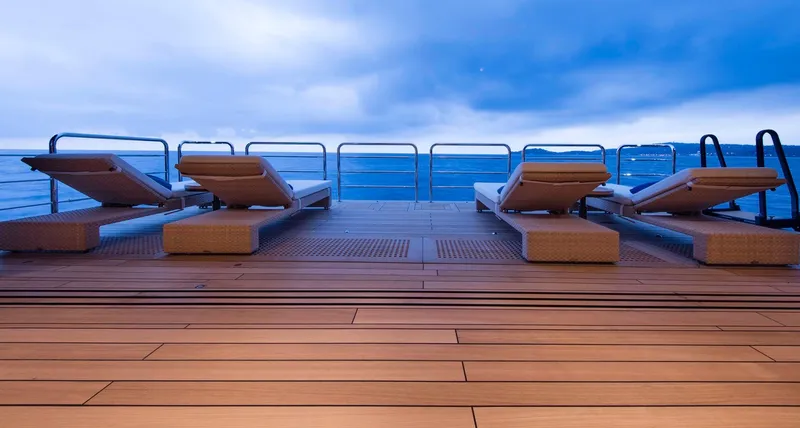 Luna Yacht Photos Pics Luxurious yacht deck with sun loungers, ocean view, and cloudy sky, Custom Lloyd Werft 2010.