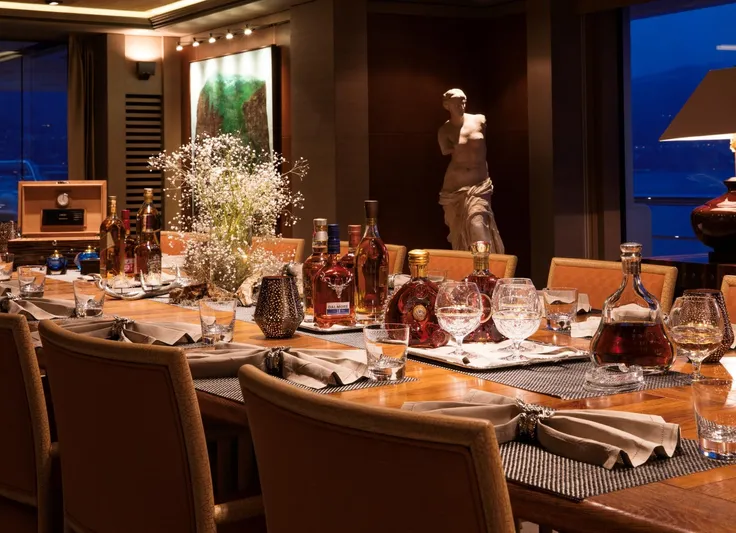 Luna Yacht Photos Pics Luxurious dining setup on a 2010 Custom Lloyd Werft yacht, featuring elegant decor and fine spirits.