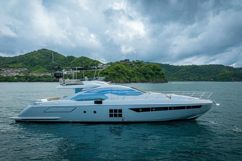 Carpe Diem Yacht Photos Pics 2017 Azimut 77S yacht cruising near lush green coastline under cloudy skies.